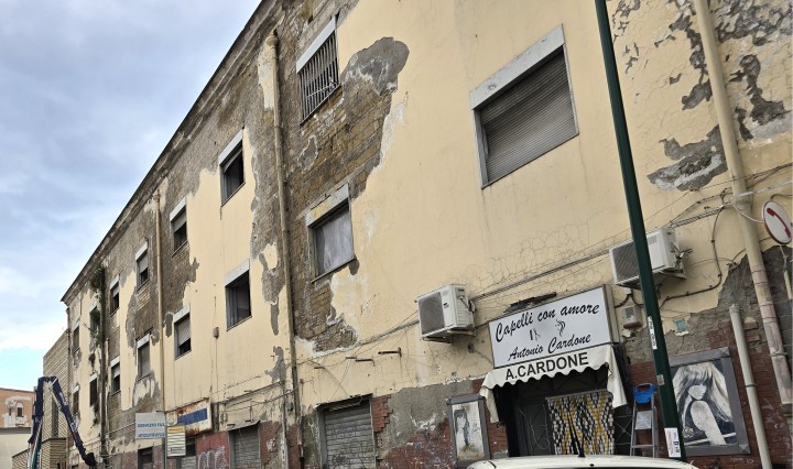 Distacco diffuso di intonaco cementizio su muratura in tufo con esposizione del supporto e degrado esteso della facciata